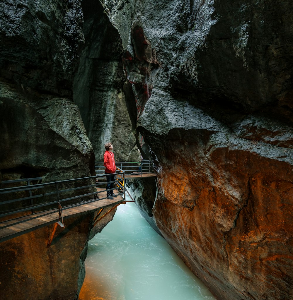 man looking upward while standing in front of balustrade inside tunnel