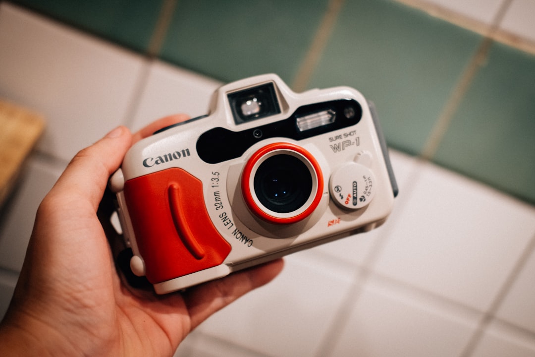 white and red canon bridge camera