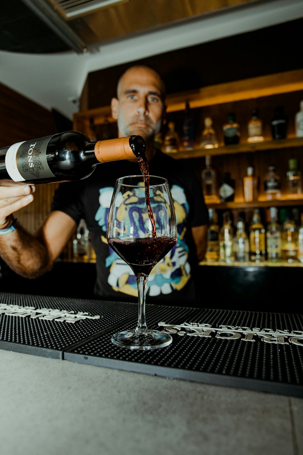 man standing and pouring wine on glass