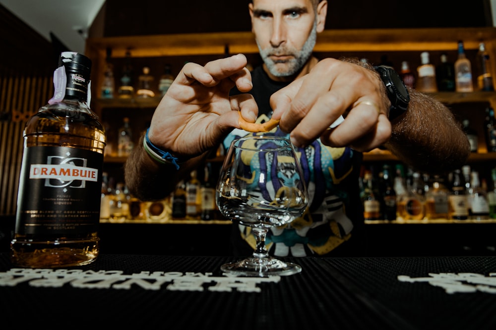 man putting pastry on wine glass