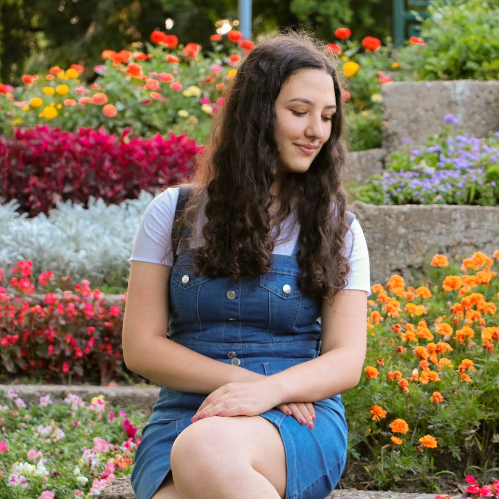 woman sitting near flower garden