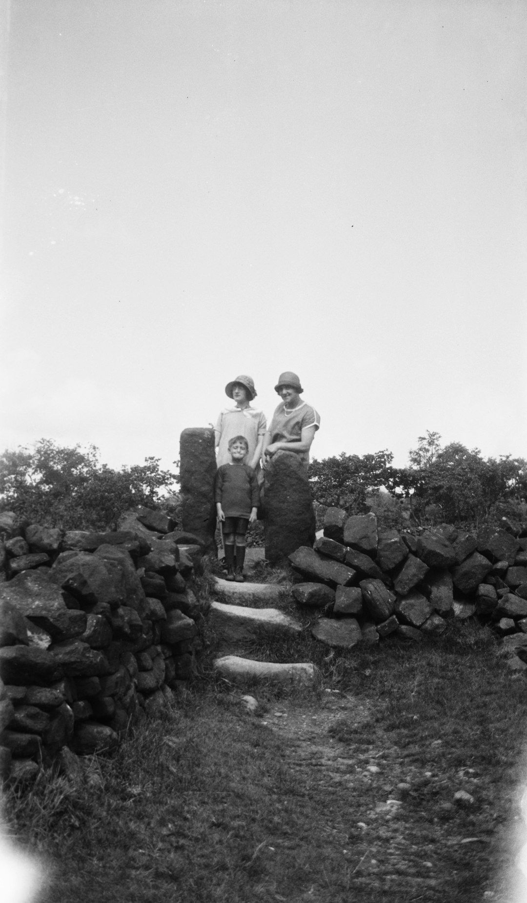 three person standing between rocks