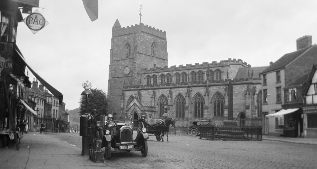 grayscale photography of people and vehicles near castle