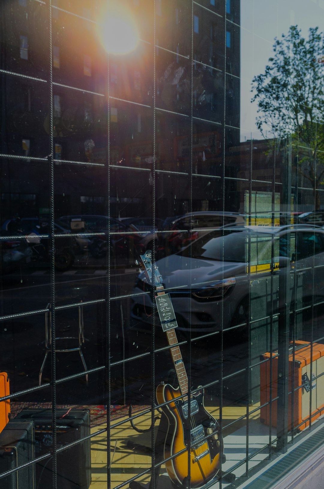 electric guitar on stand beside glass window