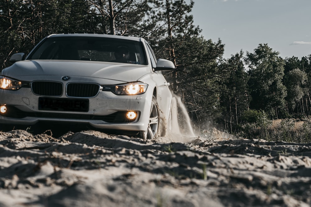 coche BMW blanco en camino de tierra