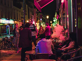 Evening view of downtown caffe’s shisha lounge with guests relaxing and soft ambient lighting.