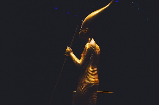 a statue of an egyptian woman holding a staff
