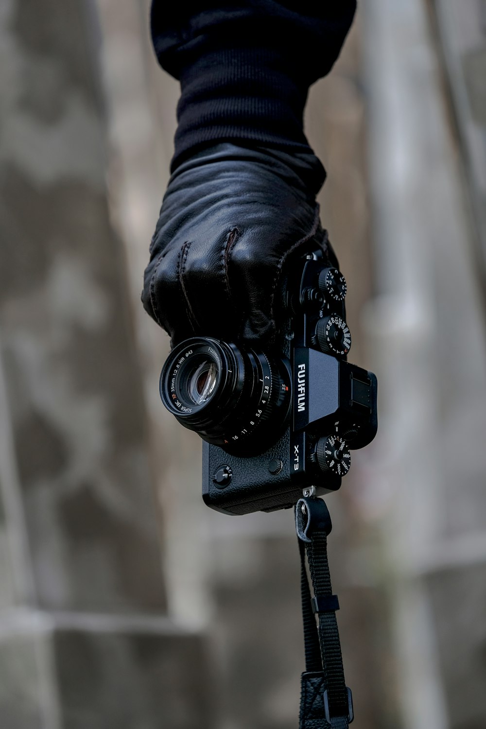 la mano de la persona que sostiene la cámara de puente Fujifilm negra
