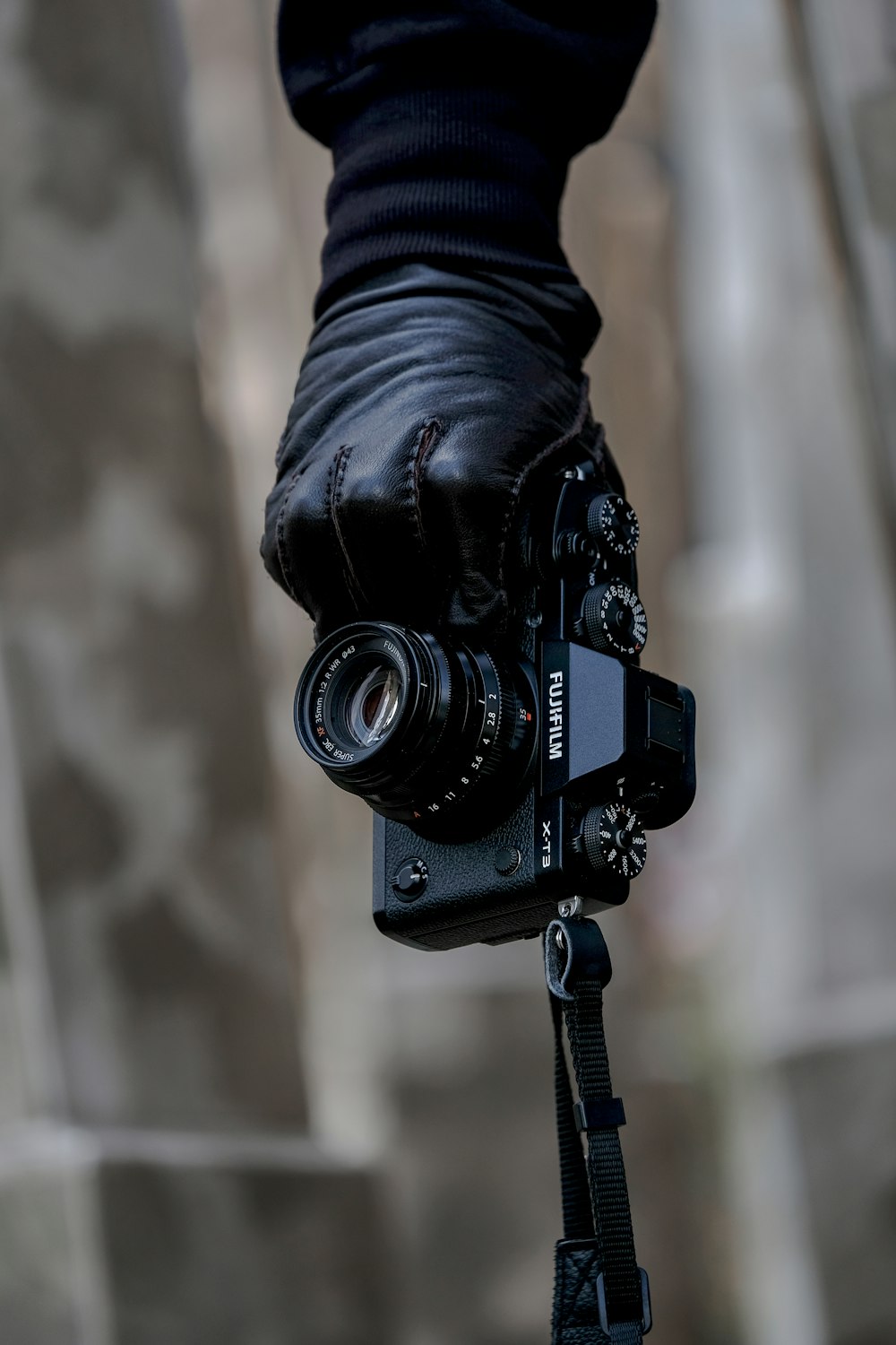 Die Hand einer Person hält eine schwarze Fujifilm-Bridgekamera