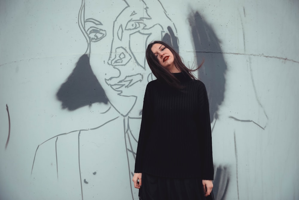 woman standing in front of wall with mural