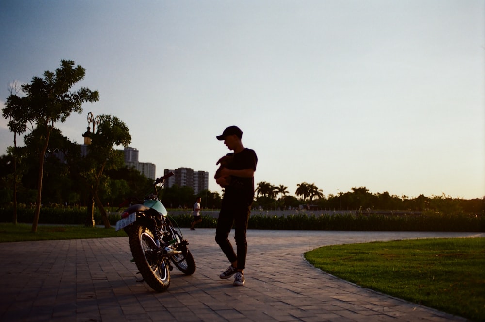 man standing beside motorcycle