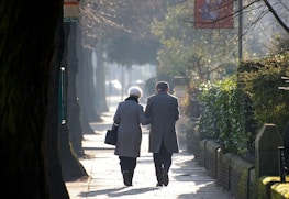 man and woman holding hands while walking