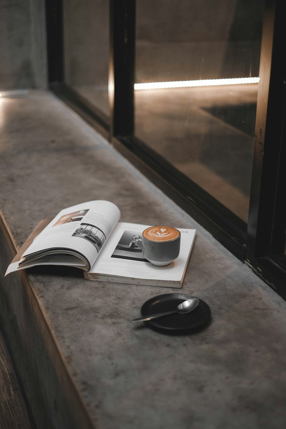 flaches Fokusfoto einer grauen Keramiktasse auf einem Buch