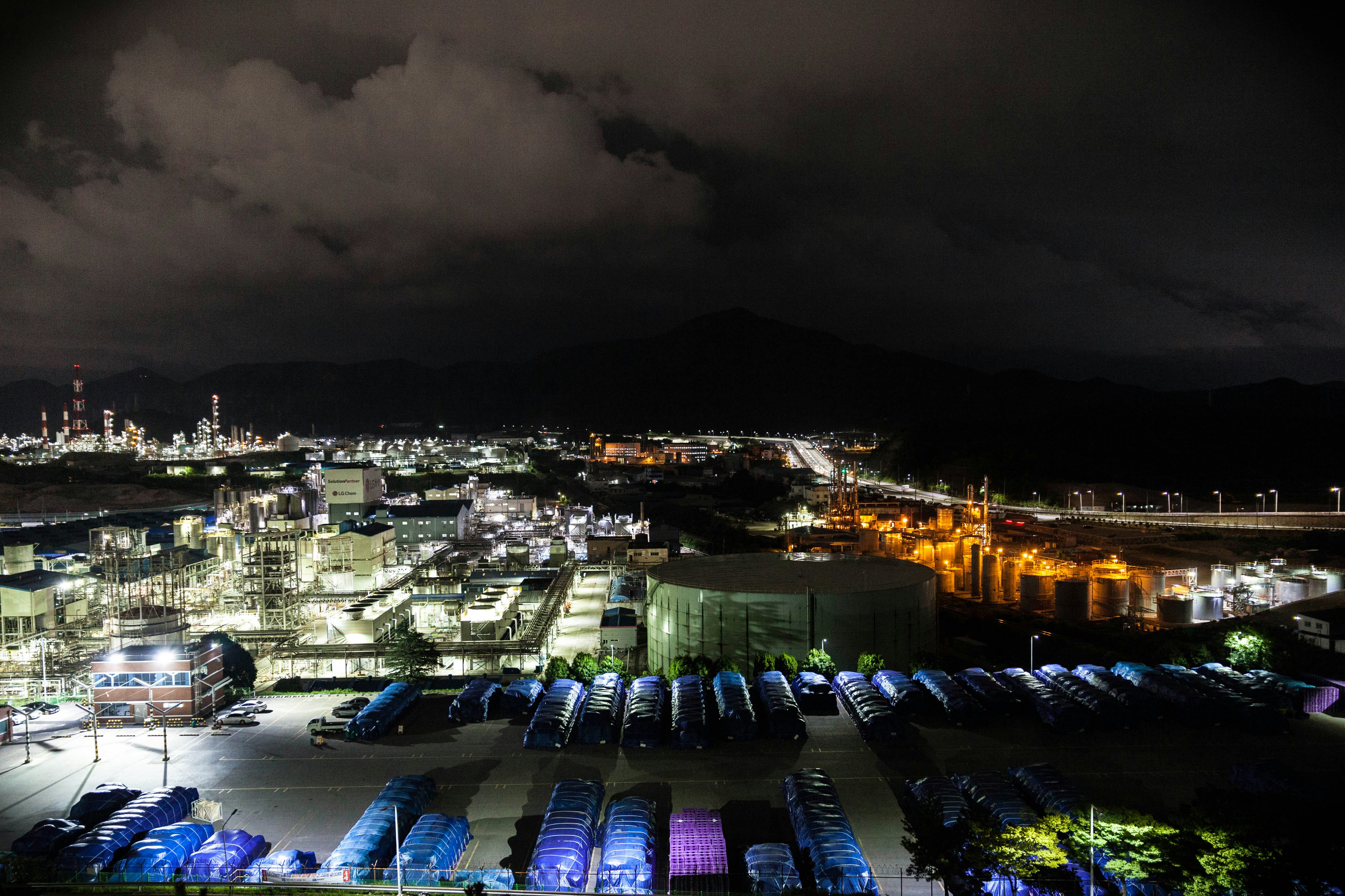 aerial view of parking space near factory at nighttime