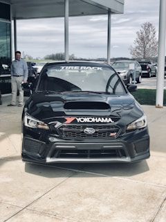 Happy customer beside their freshly tuned vehicle with subi-remap branding in the background