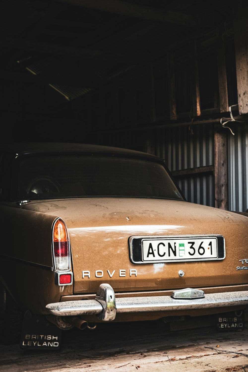 classica auto Range Rover marrone accanto al muro di metallo