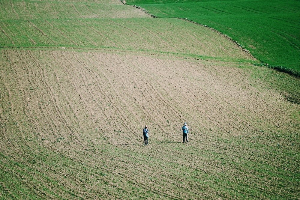 two person standing on open field during daytime