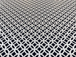 Square image of a hand-tufted rug with bold geometric patterns in black and white.