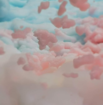 A whimsical scene depicting fluffy, cloud-like formations in pastel pinks and blues. The soft textures blend seamlessly, giving a dreamy and ethereal quality.