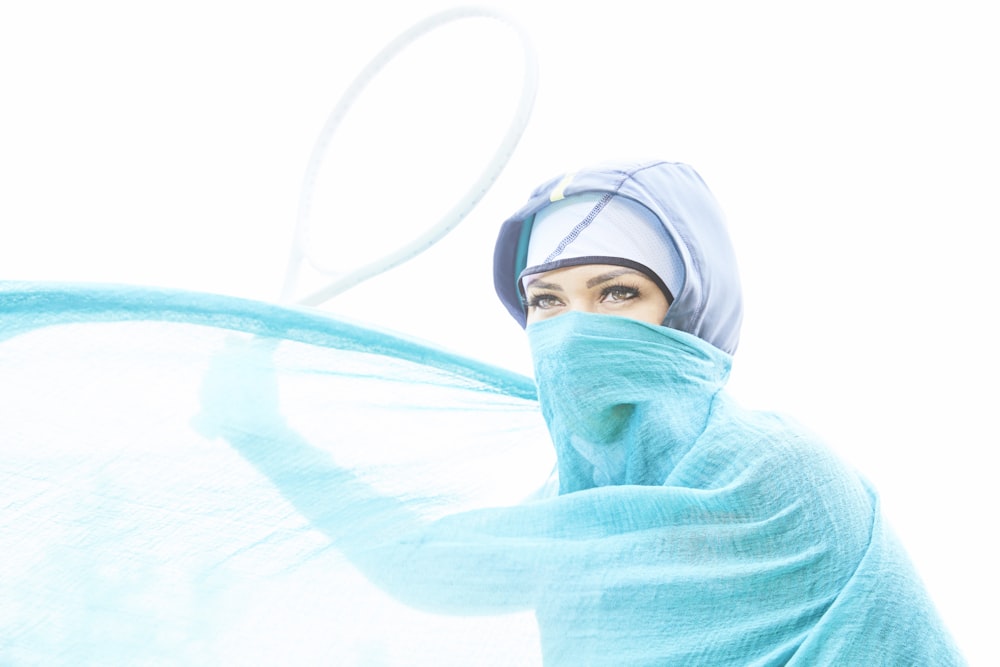 woman with green cover in her face standing