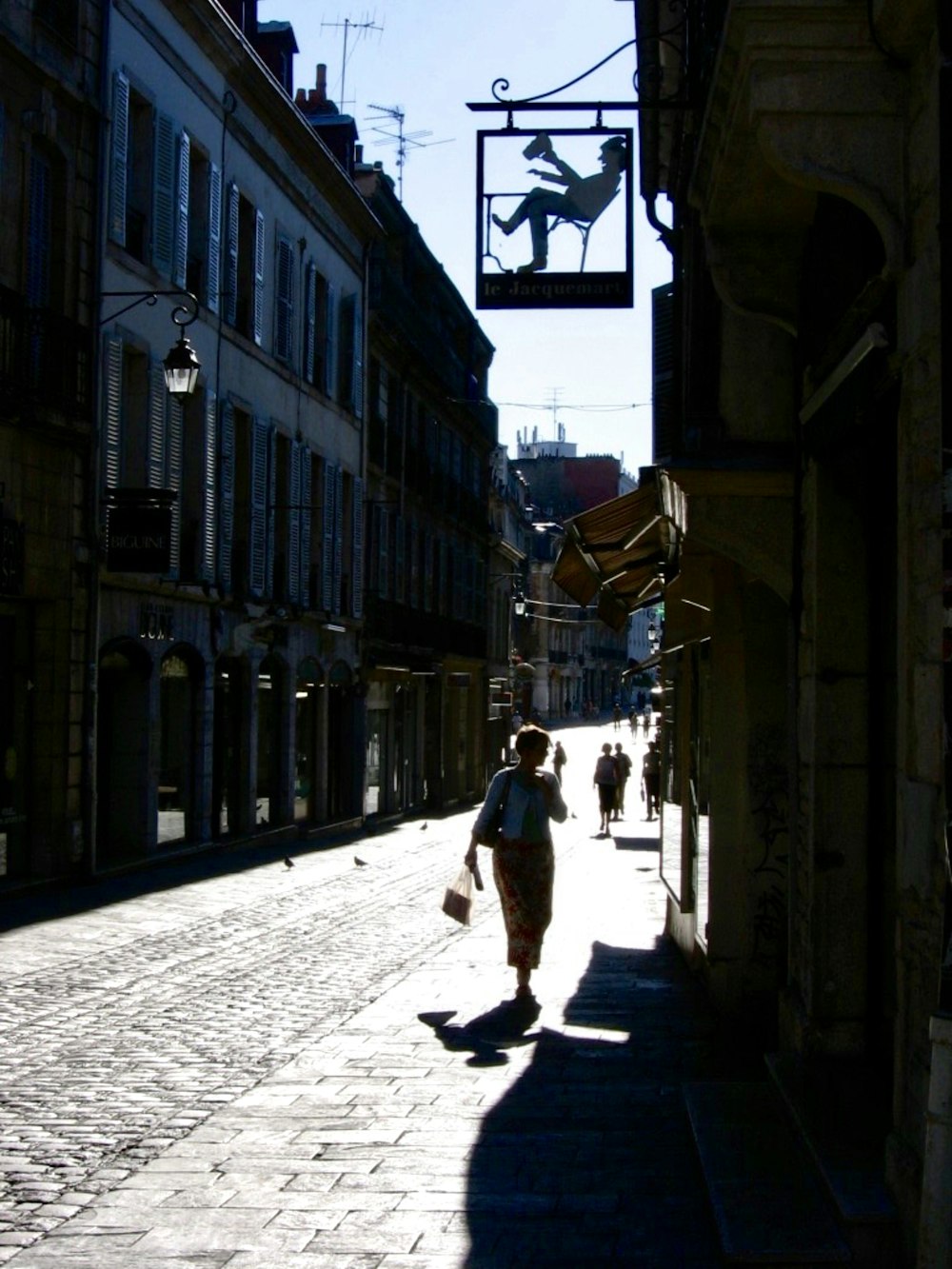 Person mit weißem und rotem Rock, die tagsüber auf der Straße spazieren geht