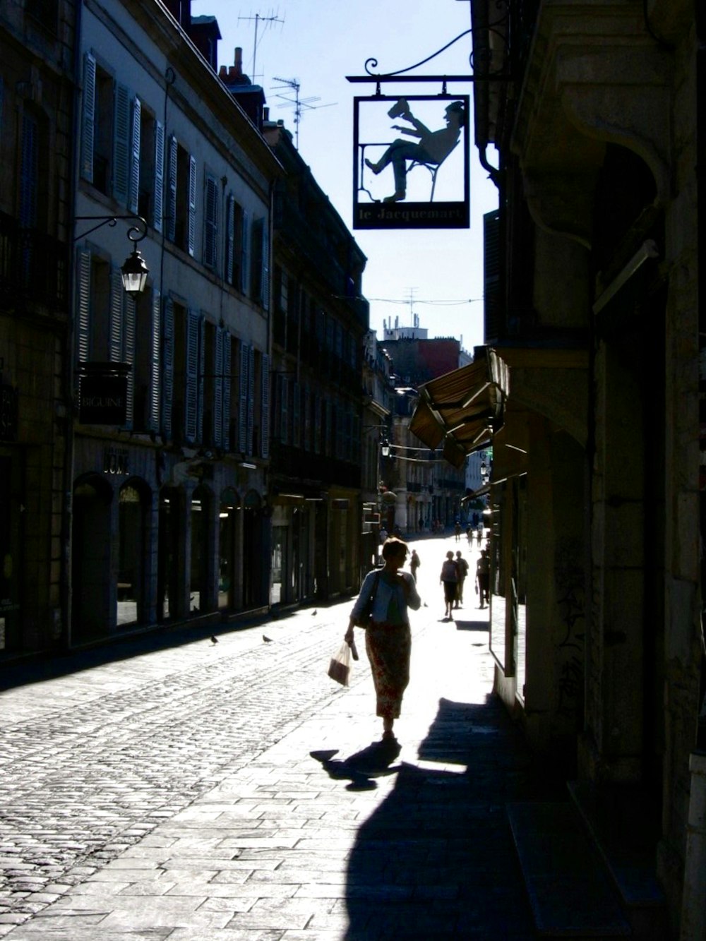 Persona che indossa gonna bianca e rossa che cammina sulla strada durante il giorno