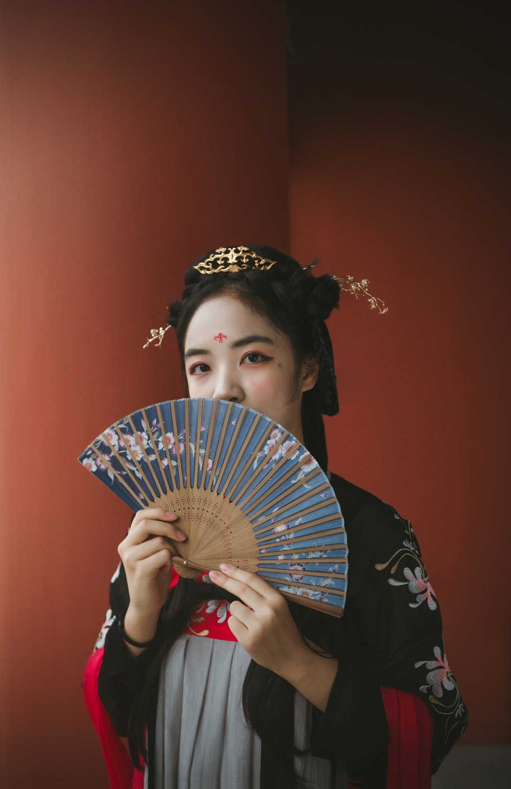 women holding a fan in a room