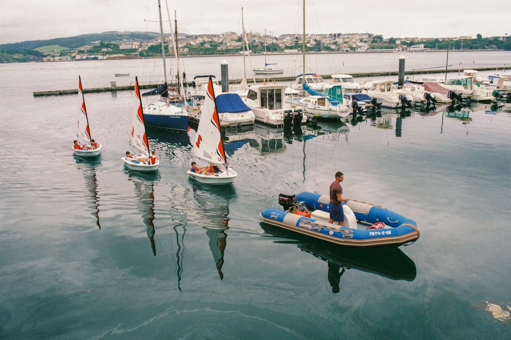 man riding blue and white inflatable boat near boardwalk