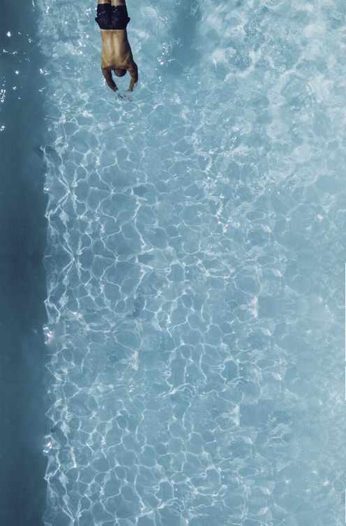 person about to dive on swimming pool