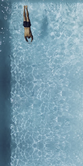 person about to dive on swimming pool