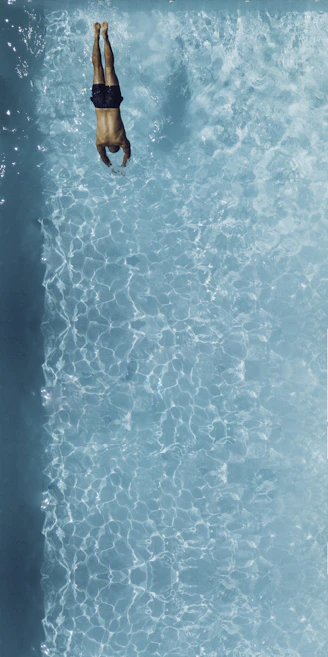 person about to dive on swimming pool