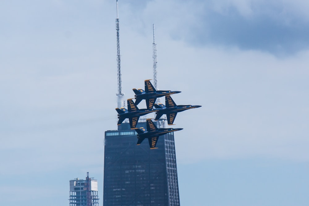 four airplanes in mid air near high-rise building
