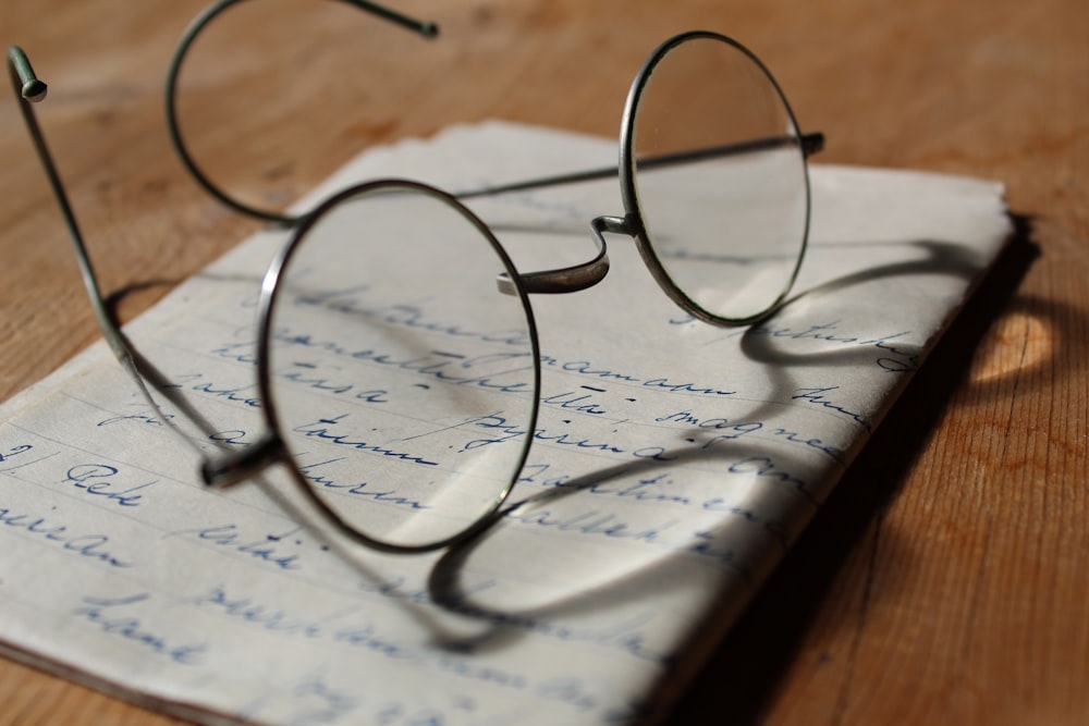 silver-colored framed eyeglasses on white printer paper