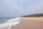 A serene beach view with palm trees and gentle waves, perfect for a relaxing getaway.