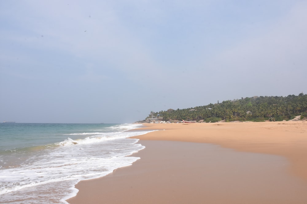 a sandy beach with waves coming in to the shore