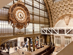 Visitors admiring a large American grandfather clock in the museum gallery.