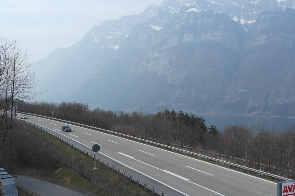 black vehicles on road near mountain at daytime