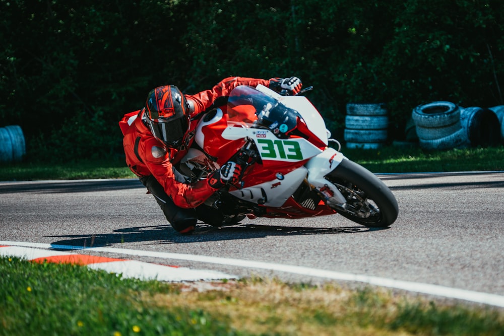 person riding and bending sports bike on track field during daytime