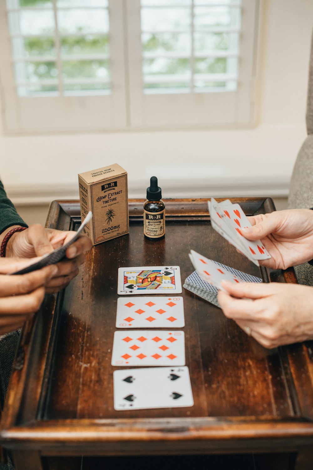 two persons holding playing cards