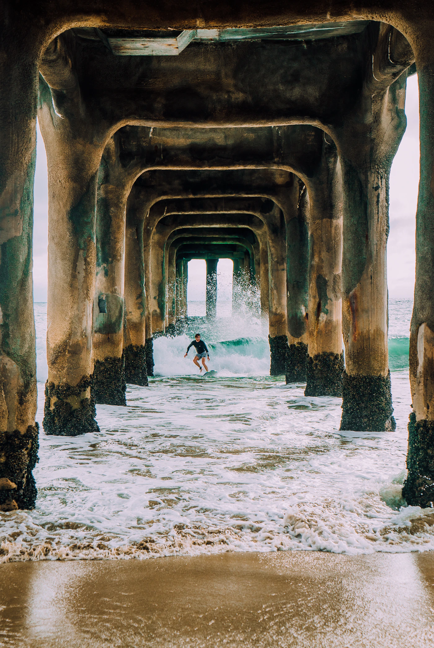 Surfer riding a wave with a surfboard in a vertical ocean scene