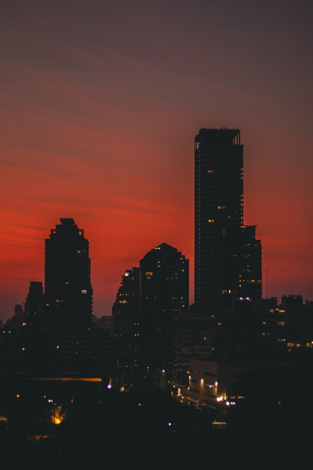 silhouette of buildings under orange sky