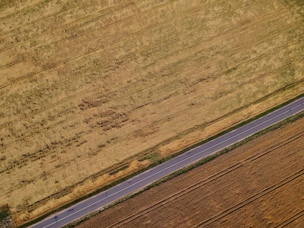 an aerial view of a road running through a field