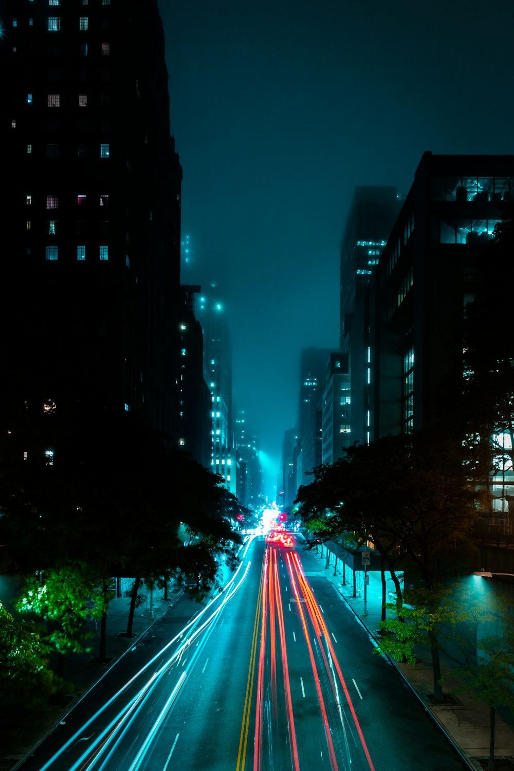 timelapse photo of vehicle on road between buildings