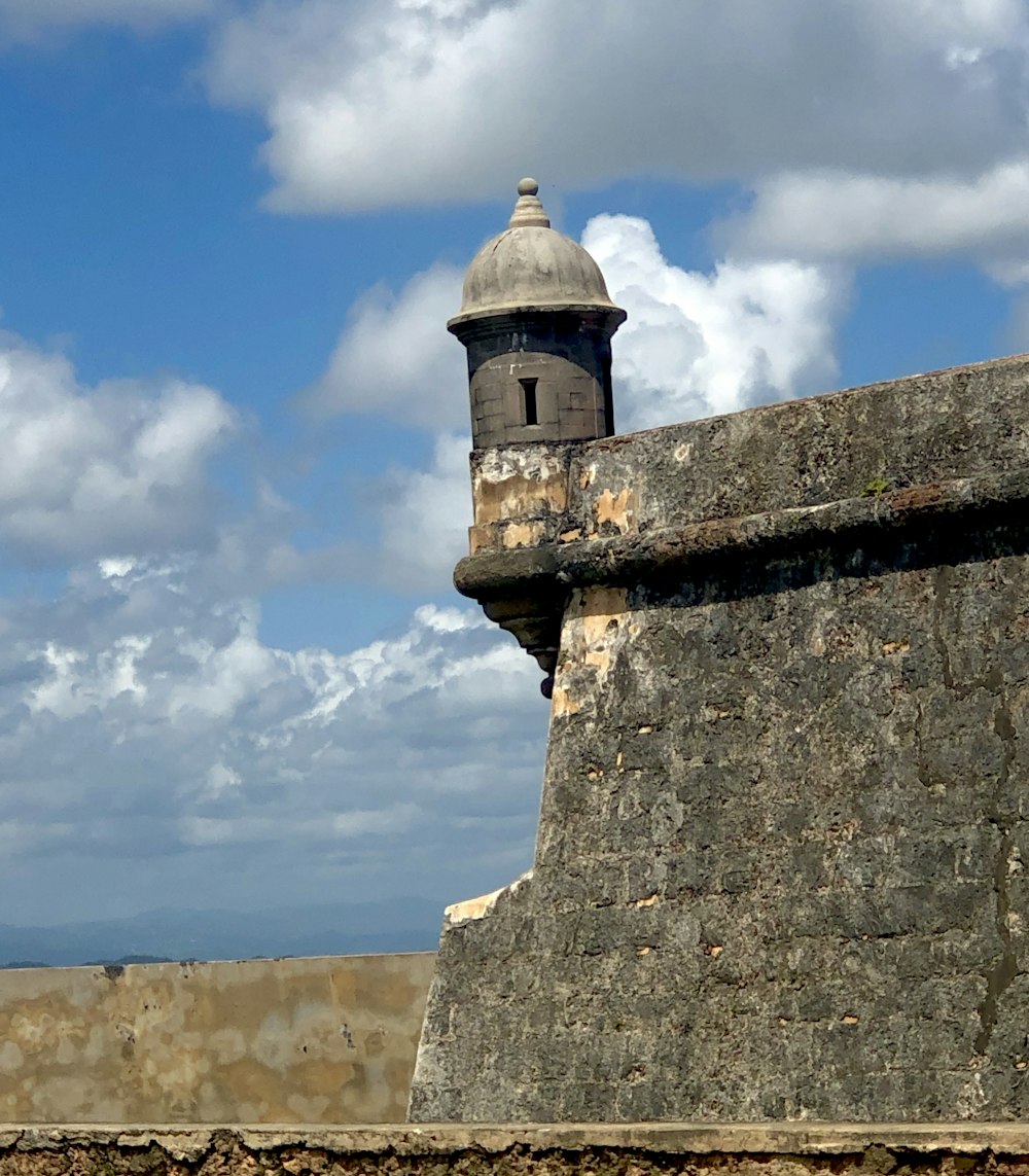 a stone wall with a clock tower on top of it