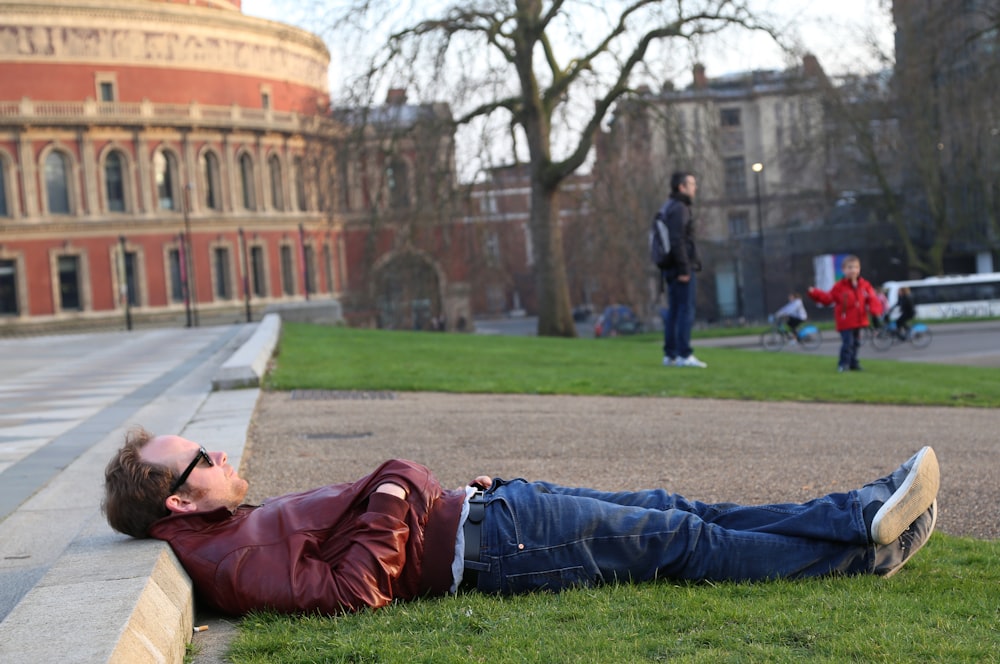 man lying on grass field
