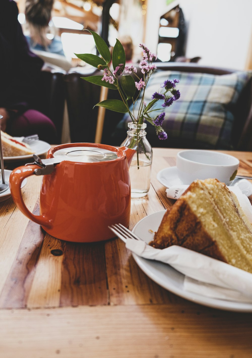 orange teapot beside bread