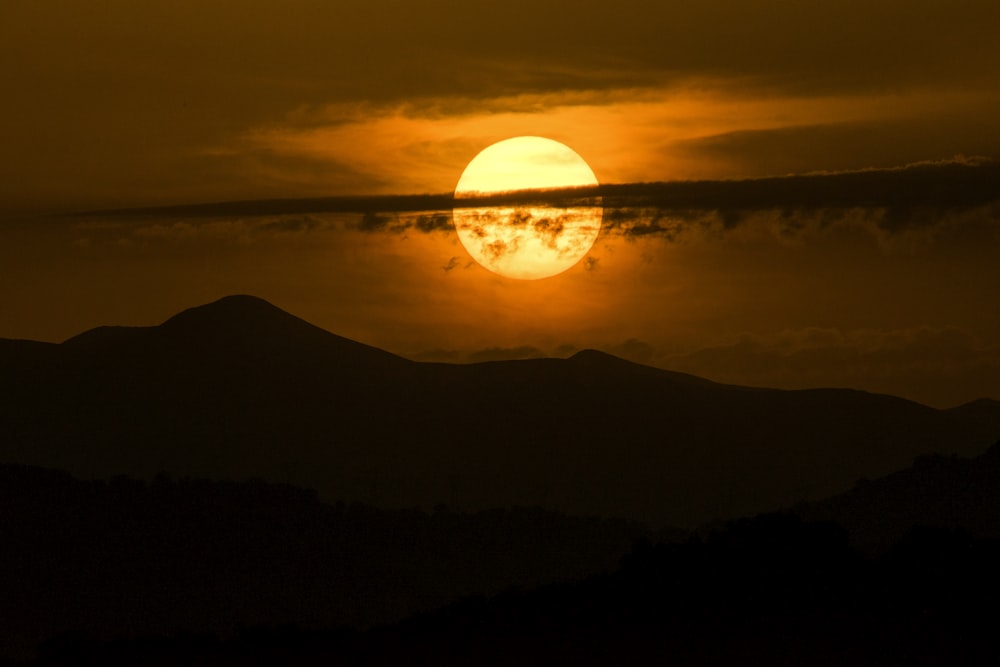 silhouette photography of mountain and sun