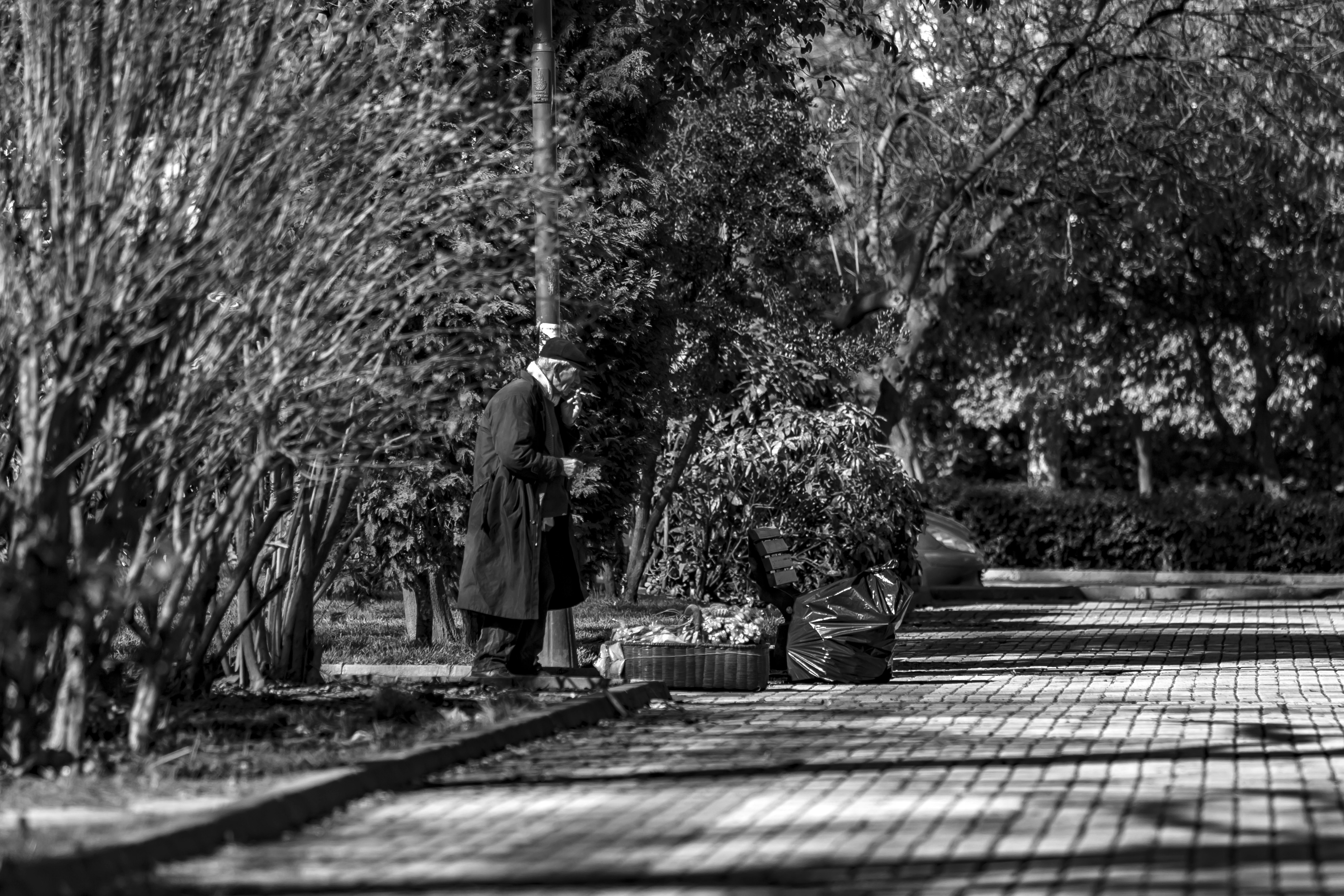 Greyscale photography of man standing on curb during daytime photo