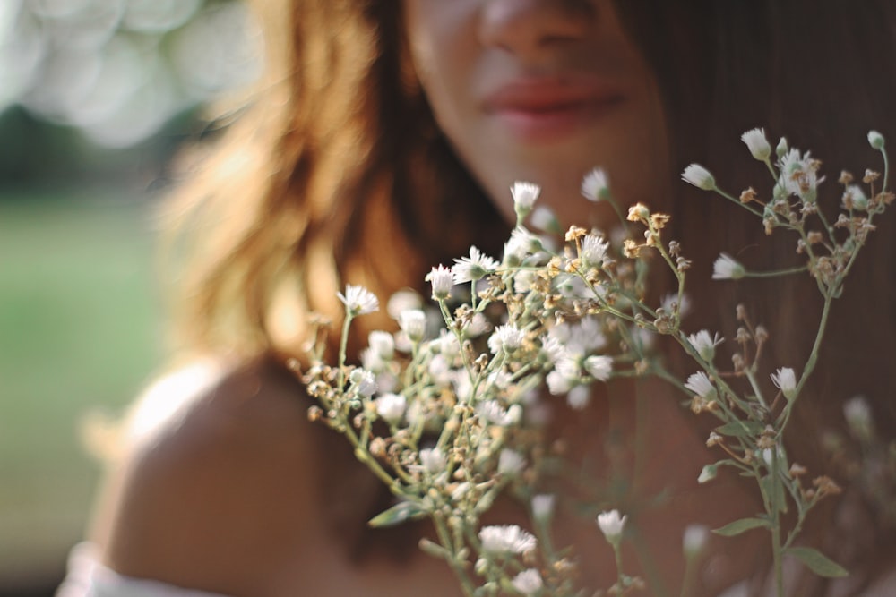 mujer sosteniendo flor