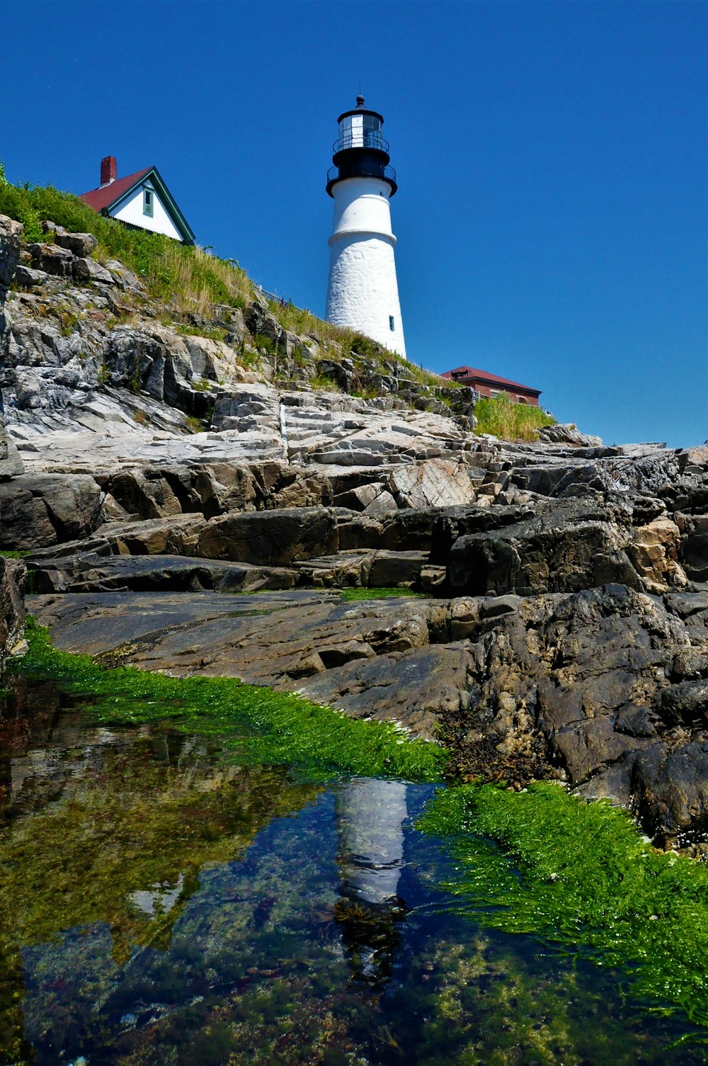 white concrete lighthouse near house